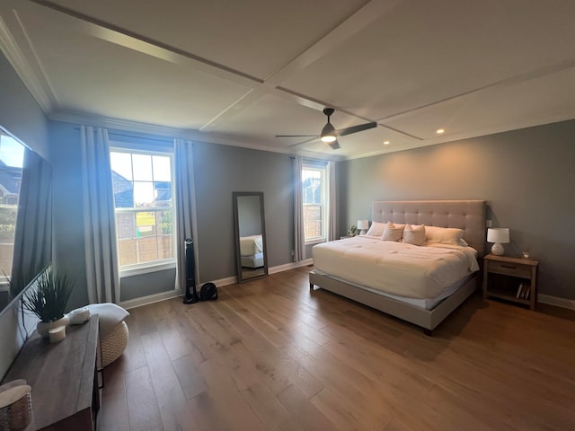 bedroom with hardwood / wood-style flooring, ceiling fan, ornamental molding, and coffered ceiling