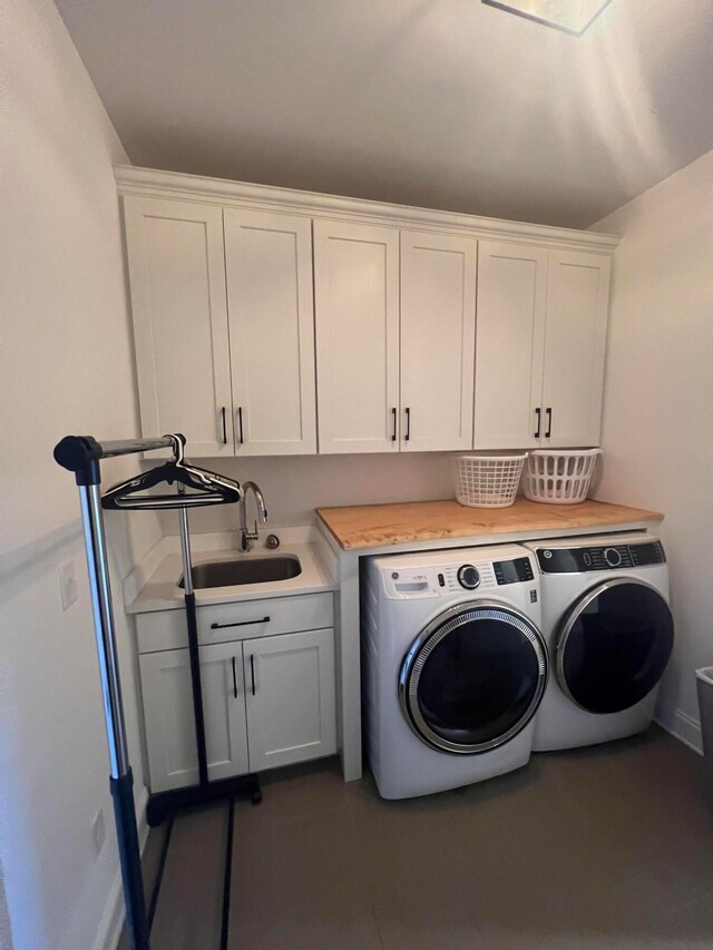 laundry area with cabinets, washing machine and dryer, and sink