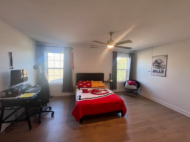 bedroom with wood-type flooring, multiple windows, and ceiling fan