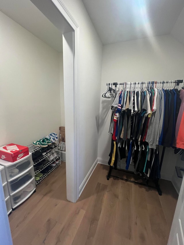 spacious closet featuring hardwood / wood-style flooring and vaulted ceiling