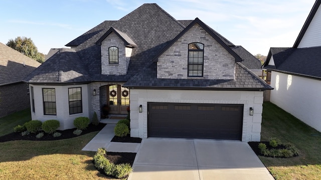 french country style house featuring a front yard, french doors, and a garage