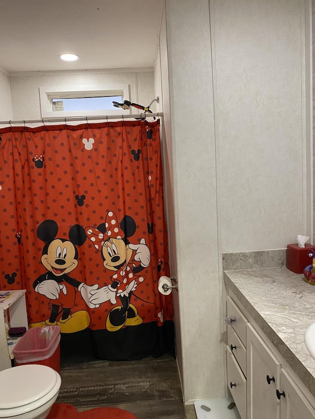 bathroom featuring a shower with shower curtain, hardwood / wood-style floors, vanity, and toilet