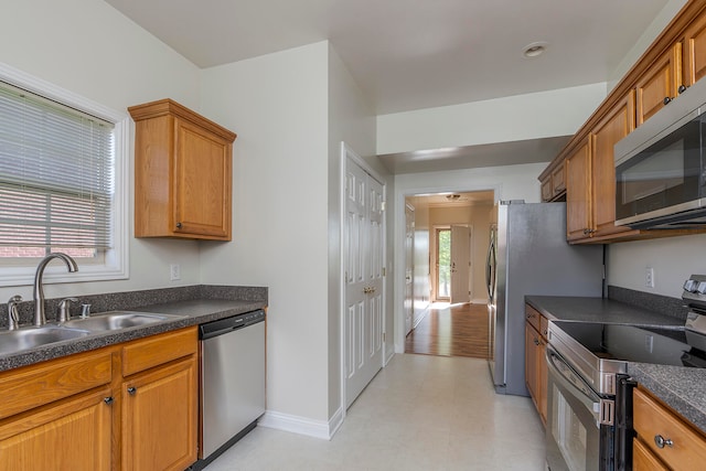 kitchen with sink, appliances with stainless steel finishes, and light wood-type flooring