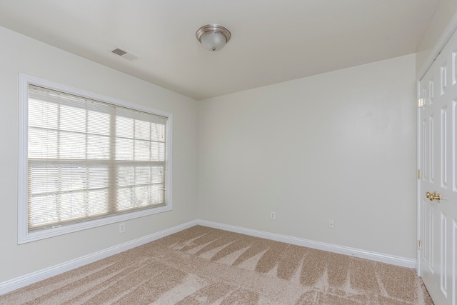 carpeted spare room featuring plenty of natural light