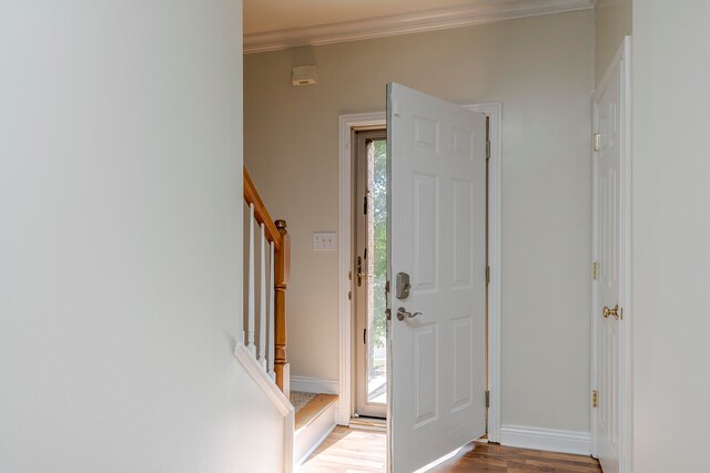 entryway with hardwood / wood-style floors, crown molding, and a healthy amount of sunlight