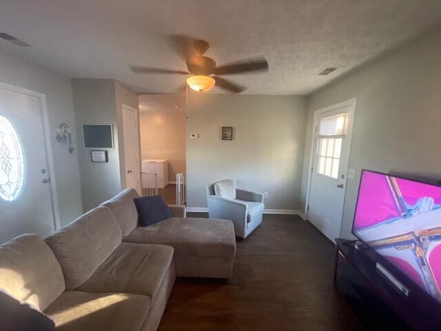 living room featuring dark wood-type flooring and ceiling fan