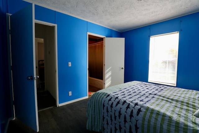 bedroom featuring dark hardwood / wood-style flooring and a textured ceiling