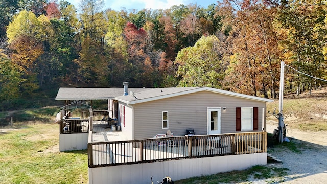 rear view of house with a yard and a wooden deck