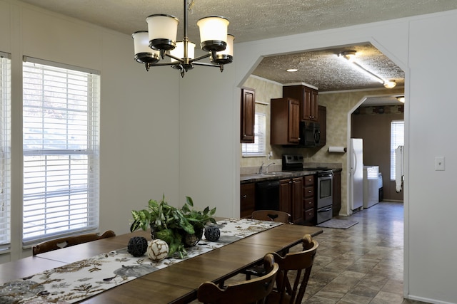 dining room with a textured ceiling, a notable chandelier, and sink