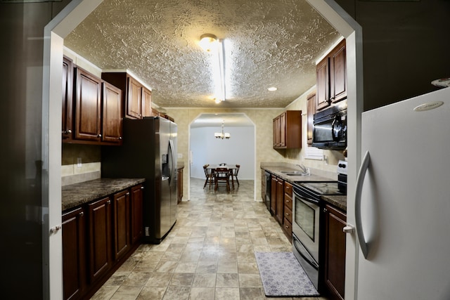 kitchen featuring a chandelier, hanging light fixtures, black appliances, and sink