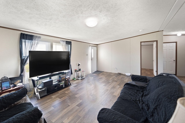 living room with ornamental molding, a textured ceiling, and hardwood / wood-style flooring