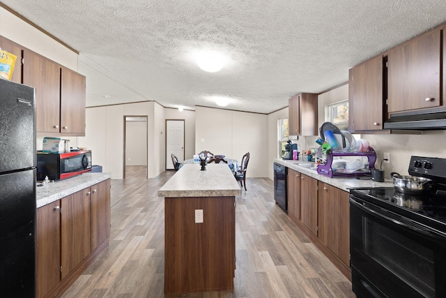 kitchen featuring a textured ceiling, black appliances, and light wood-type flooring