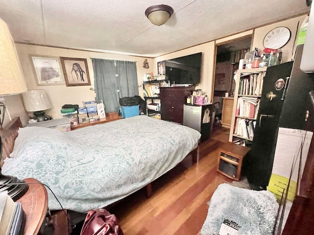 bedroom featuring a textured ceiling and hardwood / wood-style flooring