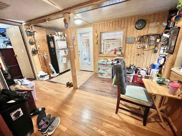 home office with wooden walls and hardwood / wood-style flooring