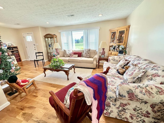 living room with a textured ceiling and light wood-type flooring