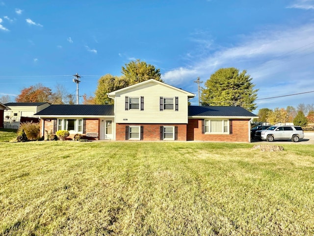 tri-level home featuring brick siding and a front lawn