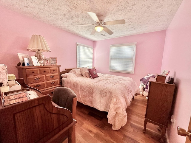 bedroom featuring ceiling fan, a textured ceiling, and hardwood / wood-style floors