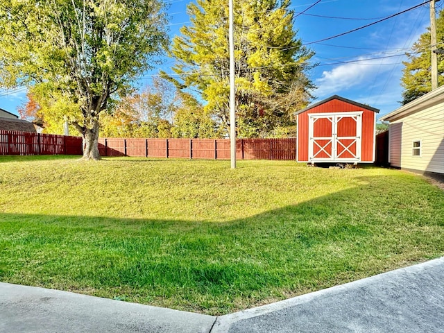 view of yard featuring a storage unit, fence, and an outdoor structure