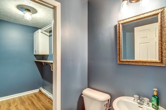 bathroom featuring toilet, a textured ceiling, sink, and wood-type flooring