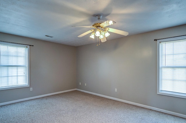 empty room with a textured ceiling, carpet, and ceiling fan