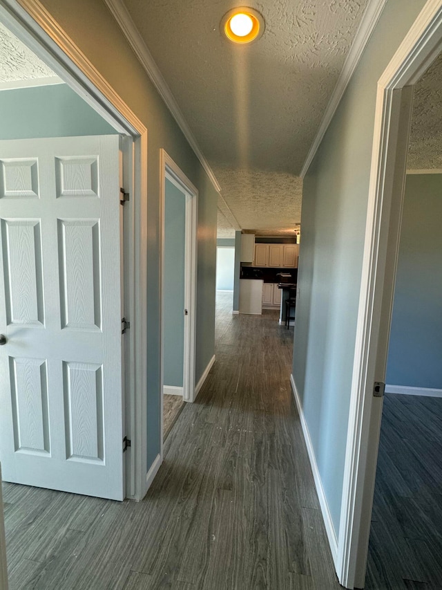 hall with a textured ceiling, crown molding, and dark hardwood / wood-style floors