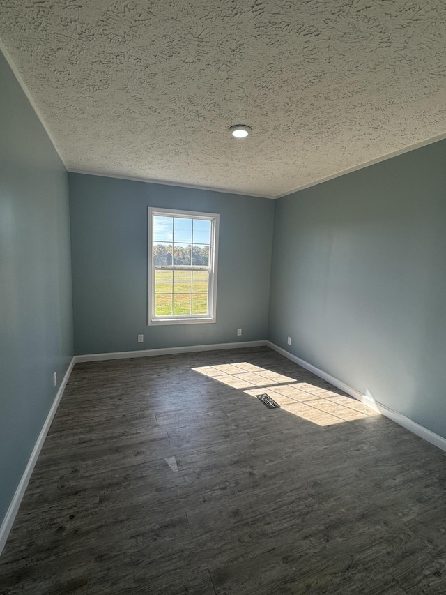 empty room featuring dark hardwood / wood-style floors and a textured ceiling