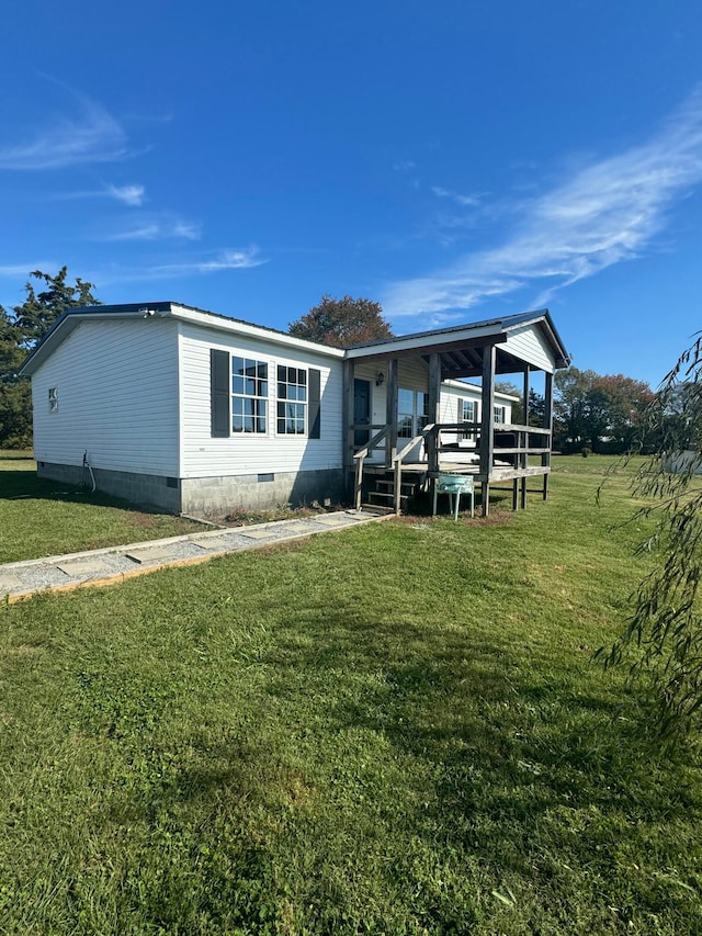 manufactured / mobile home with a front yard and a deck