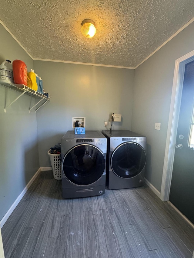 washroom with dark wood-type flooring, crown molding, a textured ceiling, and washing machine and clothes dryer