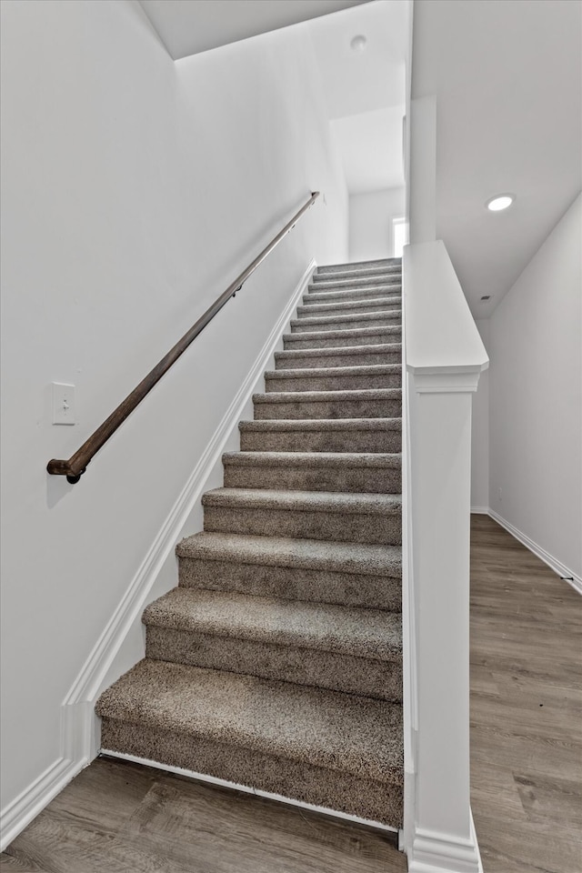 staircase with hardwood / wood-style flooring