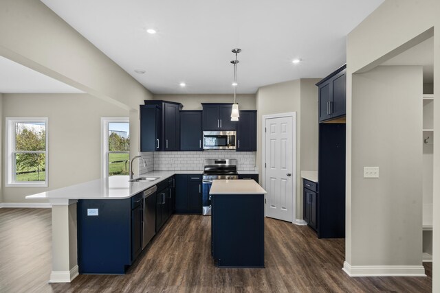 kitchen with stainless steel appliances, hanging light fixtures, kitchen peninsula, wood-type flooring, and a breakfast bar area