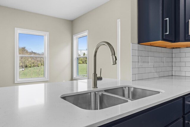 kitchen with blue cabinetry, backsplash, and stainless steel appliances