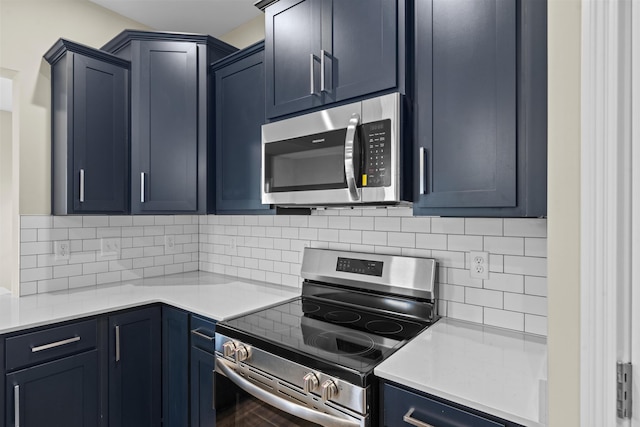 kitchen with blue cabinets, appliances with stainless steel finishes, decorative backsplash, and light countertops