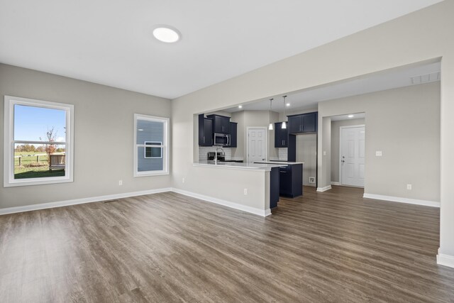 unfurnished living room with dark hardwood / wood-style floors and sink