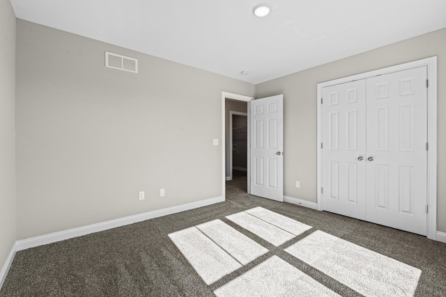 unfurnished bedroom featuring a closet, carpet flooring, visible vents, and baseboards