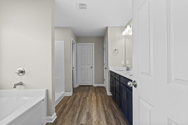 bathroom featuring a shower, hardwood / wood-style floors, and vanity