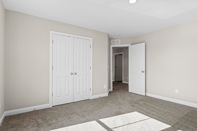 unfurnished bedroom with carpet flooring and a closet