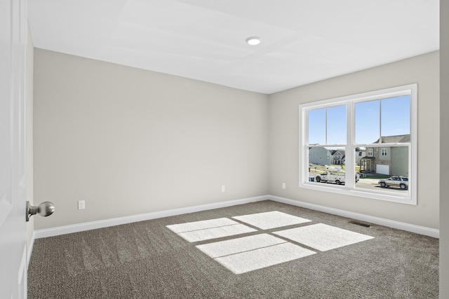 carpeted empty room featuring baseboards and visible vents