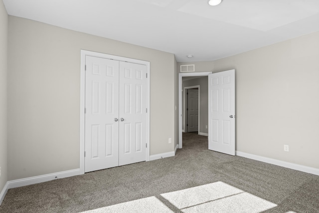 unfurnished bedroom featuring a closet, carpet flooring, visible vents, and baseboards