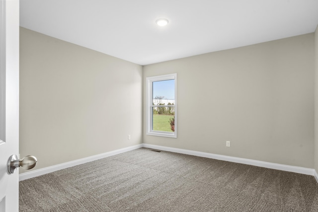 empty room featuring carpet floors and baseboards