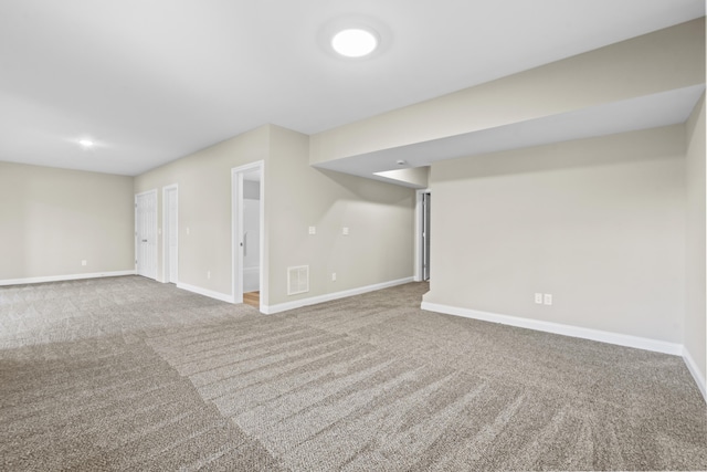 finished below grade area featuring carpet flooring, visible vents, and baseboards