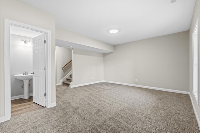 below grade area with baseboards, stairway, and carpet flooring