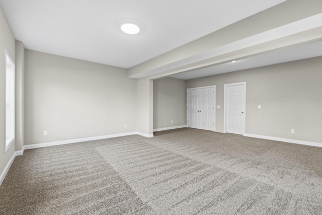 unfurnished room featuring carpet and baseboards