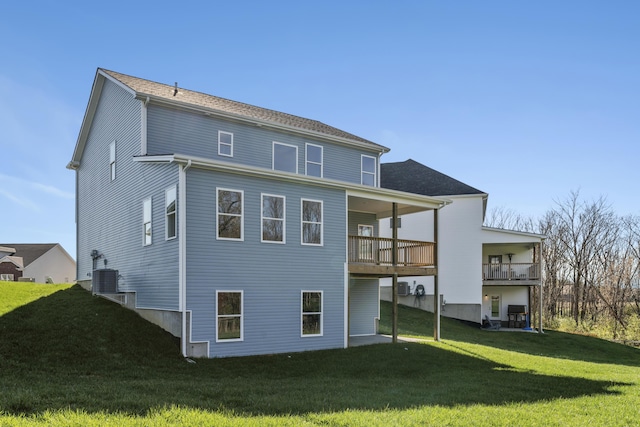 back of house with a balcony, central AC, and a lawn