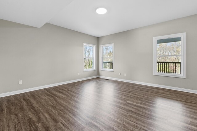 unfurnished room featuring dark wood-type flooring and baseboards