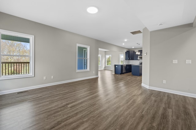 unfurnished living room featuring dark wood-style flooring, visible vents, and baseboards