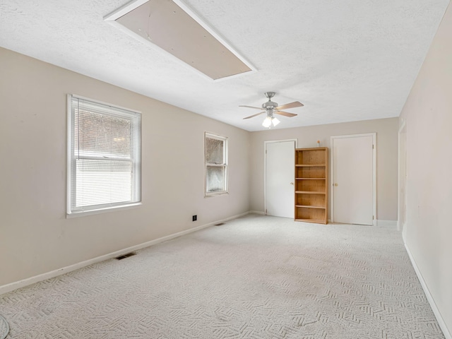 carpeted empty room featuring a textured ceiling and ceiling fan