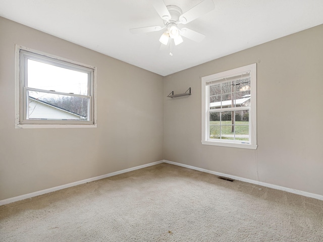 empty room featuring a textured ceiling, ceiling fan, and light carpet