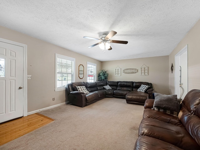 living room featuring carpet flooring, a textured ceiling, and ceiling fan