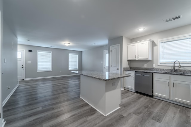 kitchen with stainless steel dishwasher, white cabinets, dark hardwood / wood-style floors, and a healthy amount of sunlight