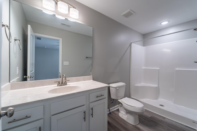 bathroom featuring vanity, toilet, walk in shower, and wood-type flooring